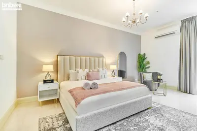 a bedroom with a large bed and a chandelier at bnbme - Dubai Marina 2BR Apt w Private Jacuzzi Pool Gym Near JBR Beach & Marina Walk in Dubai