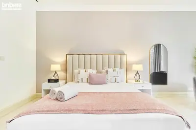 a white bedroom with a large white bed with pink pillows at bnbme - Dubai Marina 2BR Apt w Private Jacuzzi Pool Gym Near JBR Beach & Marina Walk in Dubai
