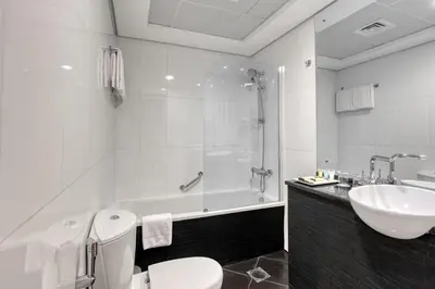 a bathroom with a toilet and a sink and a tub at Grand Heights Dubai Hotel Apartments in Dubai