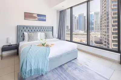 a bedroom with a bed and a large window at Frank Porter - Silverene in Dubai