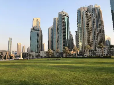 a park in front of a city with tall buildings at Elite Royal Apartment - Full Burj Khalifa & Fountain View - Brilliant - 2 bedrooms & 1 open bedroom without partition in Dubai