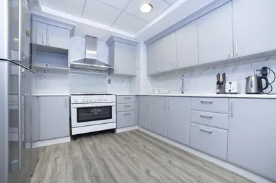a white kitchen with white cabinets and a stove at Lux 2BR in Al Khushkar Shoreline -Palm Jumeirah in Dubai