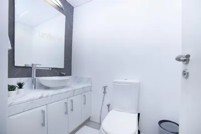 a white bathroom with a sink and a toilet at Lux 2BR in Al Khushkar Shoreline -Palm Jumeirah in Dubai