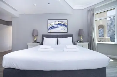 a large white bed in a room with a window at Lux 2BR in Al Khushkar Shoreline -Palm Jumeirah in Dubai