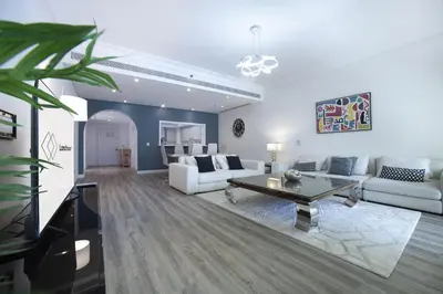 a living room with white furniture and a table at Lux 2BR in Al Khushkar Shoreline -Palm Jumeirah in Dubai