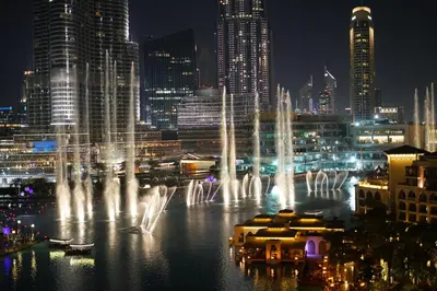 a group of water fountains in a city at night at Elite Royal Apartment - Full Burj Khalifa & Fountain View - Ruby in Dubai