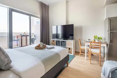 a bedroom with a large bed and a table with a television at Frank Porter - Azizi Aura in Dubai