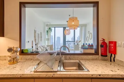 a kitchen counter with a sink and a mirror at Boho-Chic Cosy 1BR, minutes to Burj Khalifa in Dubai