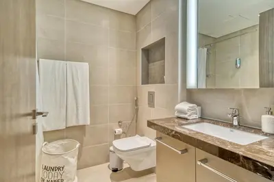 a bathroom with a sink and a toilet and a mirror at Boho-Chic Cosy 1BR, minutes to Burj Khalifa in Dubai