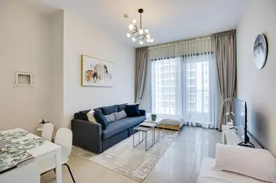 a living room with a couch and a tv at 1BD apt in Sparkle Tower by Swarovsky big capacity in Dubai