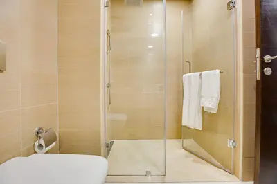 a bathroom with a toilet and a glass shower at 1BD apt in Sparkle Tower by Swarovsky big capacity in Dubai