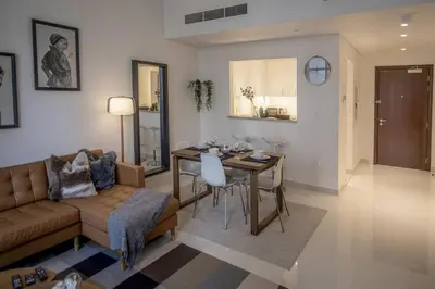 a living room with a couch and a dining room table at Elegant Apt With Balcony Minutes from Burj Khalifa in Dubai