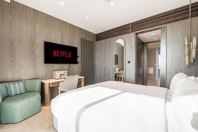 a bedroom with a white bed and a green chair at FIVE Palm Residence - Platinium Dubai in Dubai