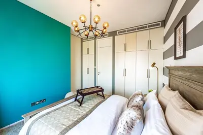 a bedroom with a bed and a blue wall at Index Tower by Radiance Vacation Stays 43rd Floor in Dubai