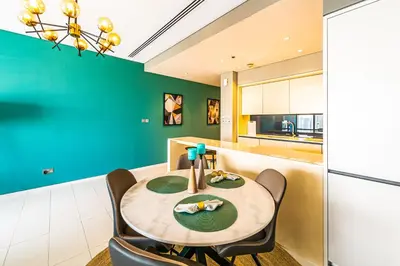 a kitchen with a table and chairs and a refrigerator at Index Tower by Radiance Vacation Stays 43rd Floor in Dubai