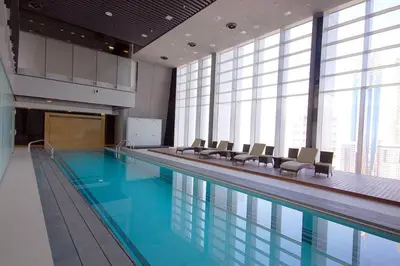 a large swimming pool with chairs in a building at Index Tower by Radiance Vacation Stays 43rd Floor in Dubai