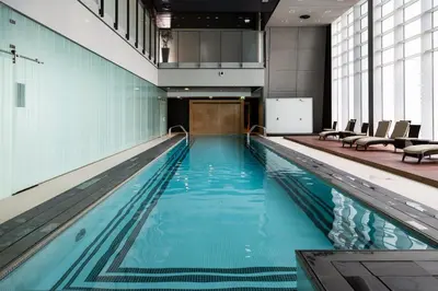 a large swimming pool with blue water in a building at Index Tower by Radiance Vacation Stays 43rd Floor in Dubai