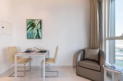 a dining room with a table and a chair at The Smart Concierge - The Vogue in Dubai