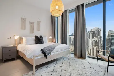 a bedroom with a bed and a large window at Breathtaking City Views From DT Apt with Terrace in Dubai