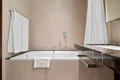 a bathroom with a bath tub and a sink at Breathtaking City Views From DT Apt with Terrace in Dubai