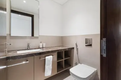 a bathroom with a toilet and a sink and a mirror at Breathtaking City Views From DT Apt with Terrace in Dubai