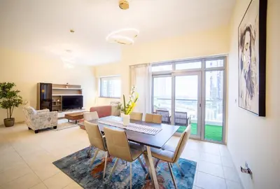 a dining room with a table and chairs and a living room at Scenic 2 Bedroom Apartment - Downtown Business Bay in Dubai