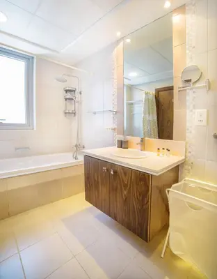 a bathroom with a sink and a tub and a mirror at Scenic 2 Bedroom Apartment - Downtown Business Bay in Dubai
