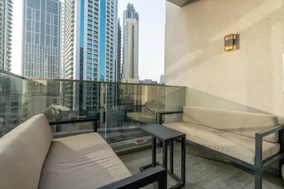 a balcony with couches and a view of a city at Bespoke Holiday Homes - Mag 318 Downtown Dubai in Dubai