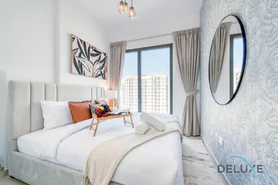 a bedroom with a large bed and a mirror at Chic 1BR in Town Square UNA Dubailand by Deluxe Holiday Homes in Dubai