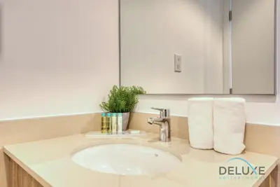 a bathroom with a sink and a mirror at Chic 1BR in Town Square UNA Dubailand by Deluxe Holiday Homes in Dubai