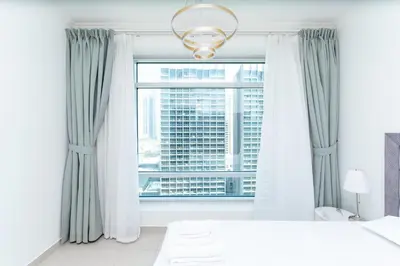 a bedroom with a window with a view of a skyscraper at Holidays R Us canal view in Dubai