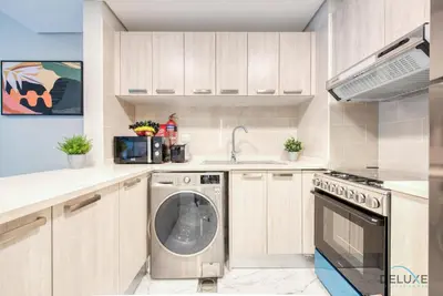 a kitchen with a washer and a dishwasher at Snug 1BR at MAG 520 Dubai South by Deluxe Holiday Homes in Dubai