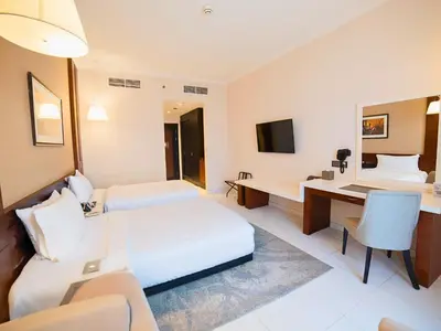 a hotel room with a bed and a desk at Asma Hotel Al Barsha in Dubai