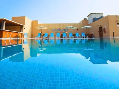 a large swimming pool with chairs and umbrellas at Asma Hotel Al Barsha in Dubai
