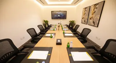 a conference room with a long table and chairs at Rose Executive Hotel - DWTC in Dubai