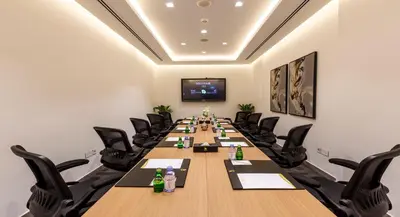 a conference room with a long table and chairs at Rose Executive Hotel - DWTC in Dubai