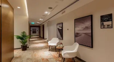 a corridor of an office with chairs and a table at Rose Executive Hotel - DWTC in Dubai