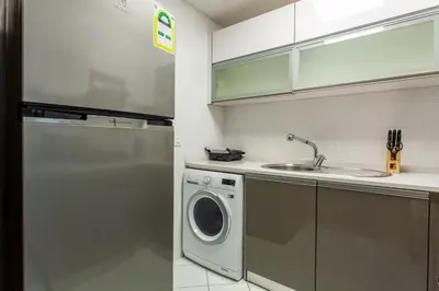 a kitchen with a washing machine and a sink at Live Modern Live Luxury - Dubai Studio City in Dubai