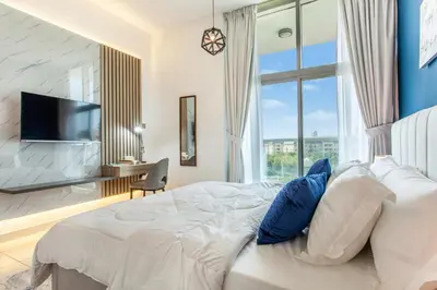 a bedroom with a bed and a large window at Live Modern Live Luxury - Dubai Studio City in Dubai