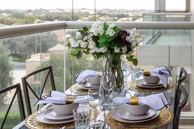 a table with a vase of flowers on top at Frank Porter - The Medalist in Dubai