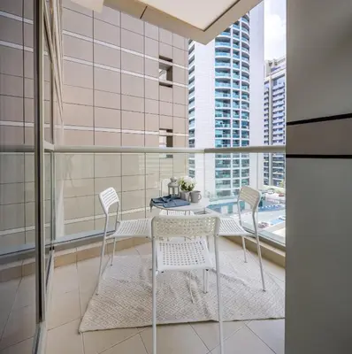 a dining room with a table and chairs and a balcony at Frank Porter - The Medalist in Dubai