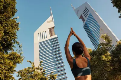 a woman doing a yoga pose in front of a tall building at Jumeirah Emirates Towers Dubai in Dubai