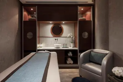 a room with a bed and a chair and a sink at Jumeirah Emirates Towers Dubai in Dubai