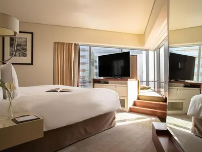 a hotel room with a large bed and a large window at Jumeirah Emirates Towers Dubai in Dubai