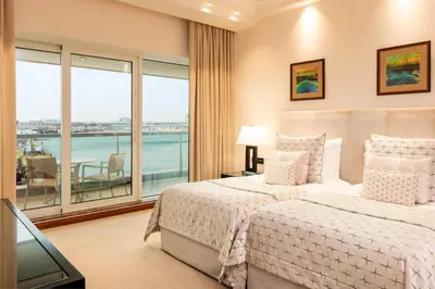 a bedroom with two beds and a large window at Grosvenor House, a Luxury Collection Hotel, Dubai in Dubai