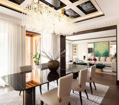 a dining room with a glass table and white chairs at Jumeirah Dar Al Masyaf Dubai in Dubai