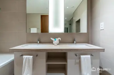 a bathroom with two sinks and a large mirror at Dream Inn Apartments- Boulevard Heights in Dubai