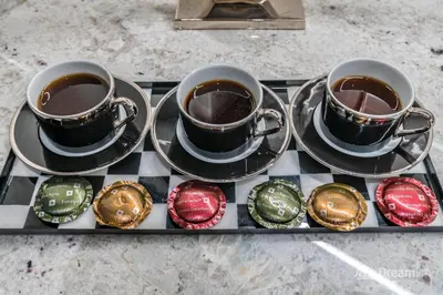 two cups of coffee on a tray with cupcakes at Dream Inn Apartments- Boulevard Heights in Dubai