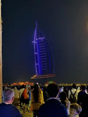 a group of people looking at a building lit up at night at Ramada Hotel, Suites and Apartments by Wyndham Dubai JBR in Dubai