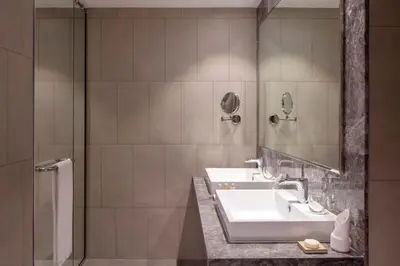 a bathroom with two sinks and a shower at The First Collection Dubai Jumeirah Village Circle, a Tribute Portfolio Hotel in Dubai